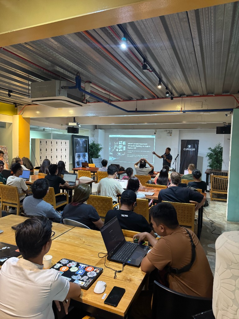 Speaker presenting on debugging with Cursor AI